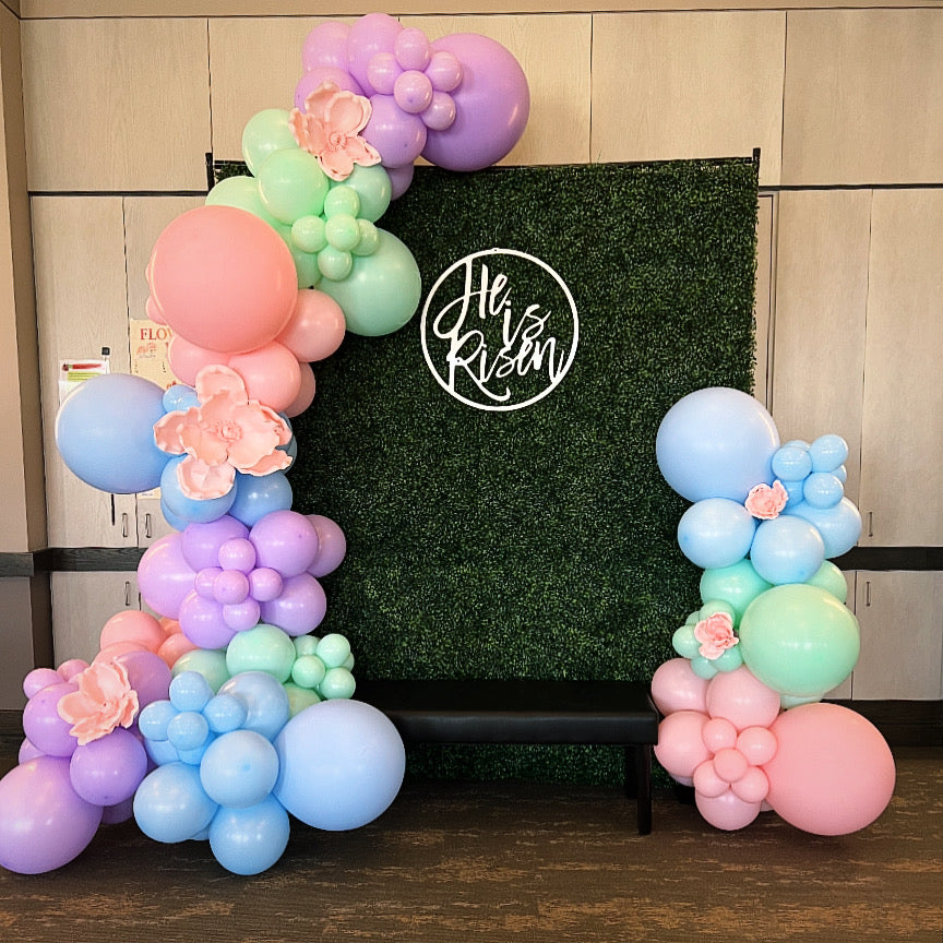 Pastel balloon flowers framing a green hedge Easter backdrop