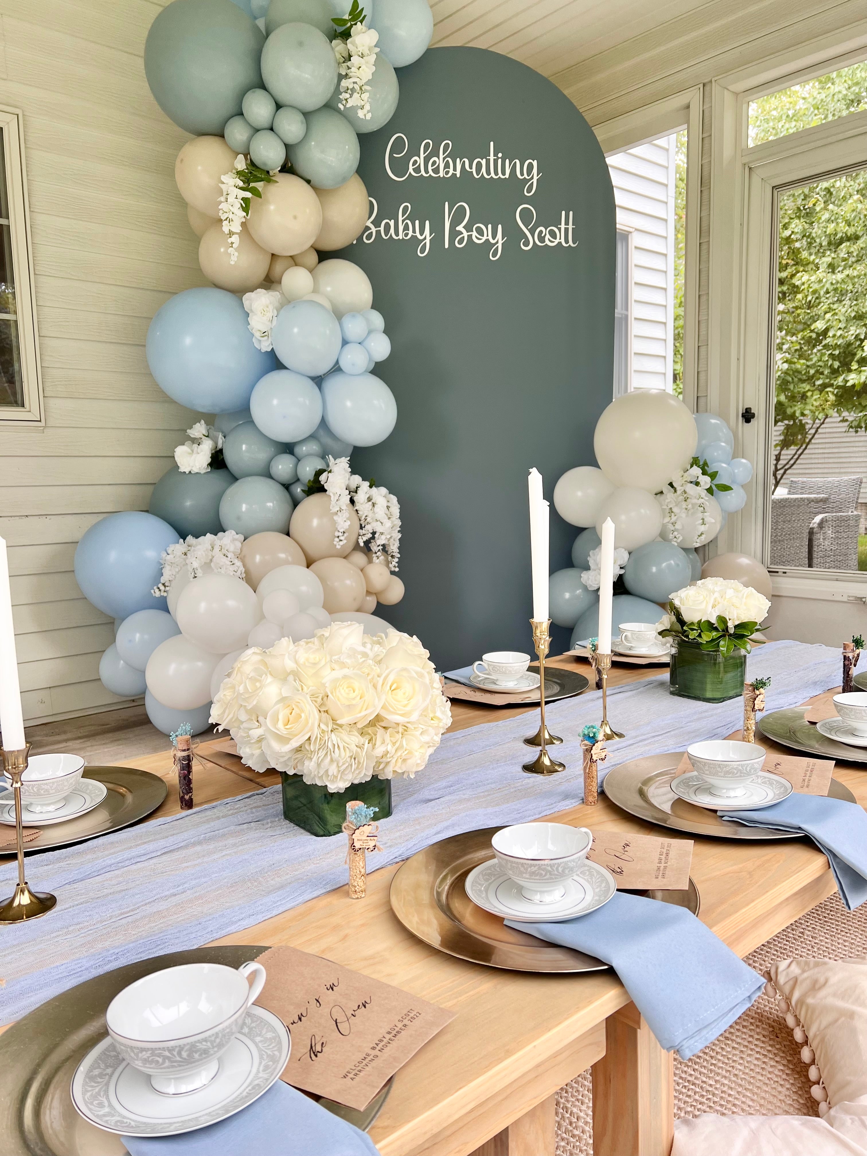 Soft blue and ivory balloons with arch backdrop for a baby boy shower